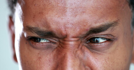 African man eyes squinting. Close-up black guy closing eyes squint