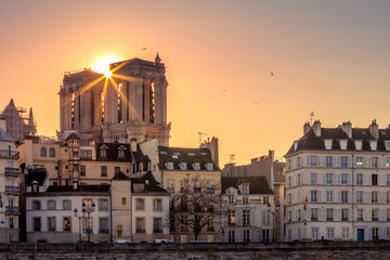 Paris, France - March 1, 2021: Beautiful Notre Dame cathedral tower with Haussmannian buildings in...