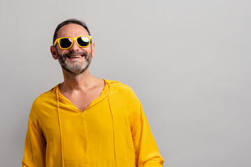 Stylish senior man wearing yellow shit and smiling