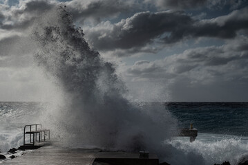 Waves crash in an intense fashion on a small dock on the northwest tip of Grand Cayman as a storm...