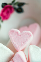 Heart-shaped marshmallows in an overturned porcelain teacup.