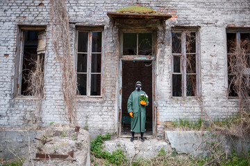 A dosimetrist scientist in protective clothing and a gas mask examines the danger zone. Close-up....