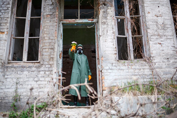 A dosimetrist scientist in protective clothing and a gas mask examines the danger zone. Close-up....