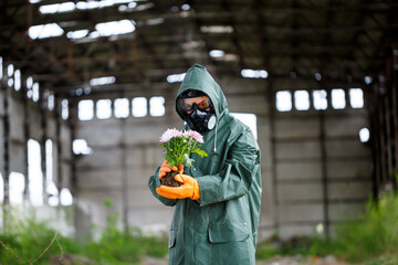 A dosimetrist scientist radiation inspector in protective clothing and a gas mask examines the...