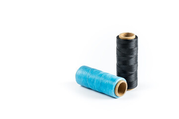 A skein of black and cyan thread. Coils of colored threads on a white background. Waxed sewing...