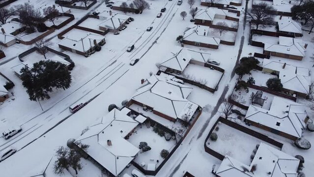 Heavy snow covered on residential neighborhood outside of Dallas, Texas, America as winter storm Landon makes landfall. Shingle roof, backyard, sidewalk under frozen icy cold weather temperature