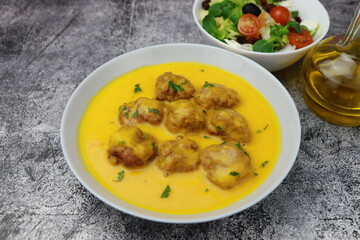 Homemade cream of pumpkin soup with meatballs on a gray background table. Front view