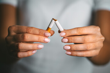 Stop smoking, quit smoking or no smoking cigarettes. Woman holding broken cigarette in hands. Woman...
