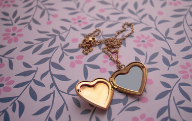 Gold Heart Necklace Close up over a flowered vintage background 