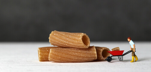 The miniature people and pasta noodles with Business concept. Pasta noodles and miniature farmer and business concept.
