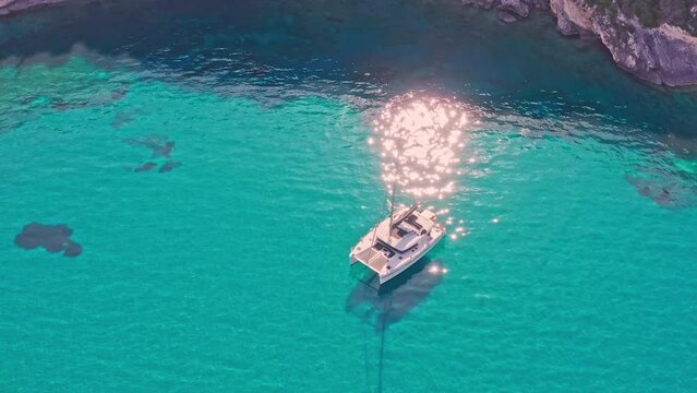Turquoise sea water of Mediterranean sea in Greece. White catamaran recreation
