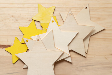 wooden stars (some painted yellow) on a wooden surface