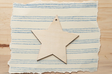 isolated wooden star-ornament on paper with lines on wood