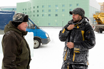 Two workers talk on the assembly site
