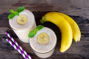 Banana fresh cocktail vanilla smoothies  fruit juice beverage healthy the taste yummy in glass drink episode good morning on wooden background from the top view.