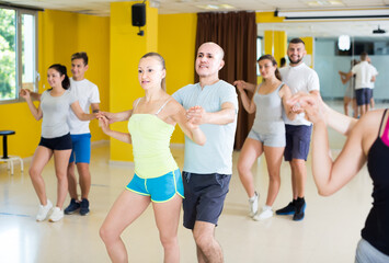 Young sporty czech girls and men learning salsa steps