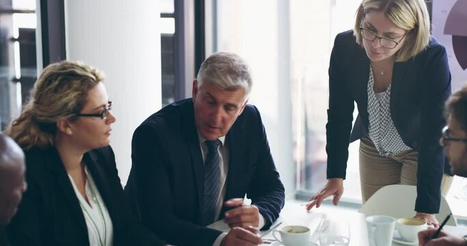He doesnt shy away from having candid business conversations. Diverse group of business people sitting in office and having a boardroom meeting. Colleagues sitting and discussing, strategy, plan