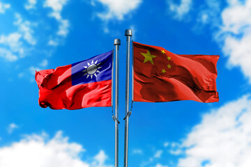 Flags of Taiwan and China on the wind against blue sky