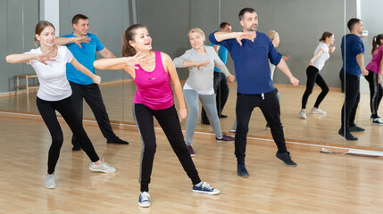 Fototapeta na wymiar Group of adult people training in gym, doing aerobics exercises