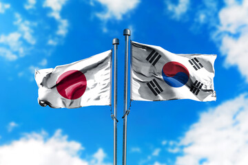 Flags of Japan and South Korea on the wind against blue sky