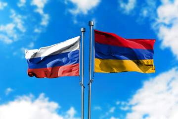 Flags of Russia and Armenia on the wind against blue sky