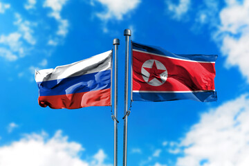 Flags of Russia and North Korea on the wind against blue sky