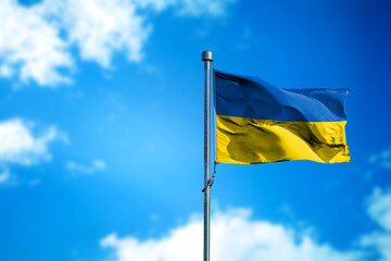 Flag of Ukraine on the wind against blue sky