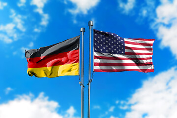 Flags of Germany and America on the wind against blue sky