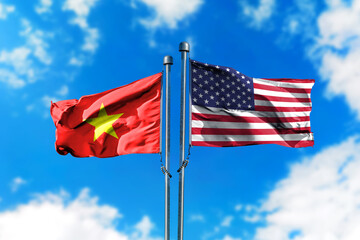 Flags of America and Vietnam on the wind against blue sky