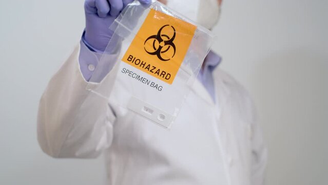 Doctor in gloves show Biohazard Specimen Bag with Positive PCR Antigen Test, pandemic concept