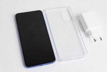 New cellphone and charger with transparent cover over isolated white background