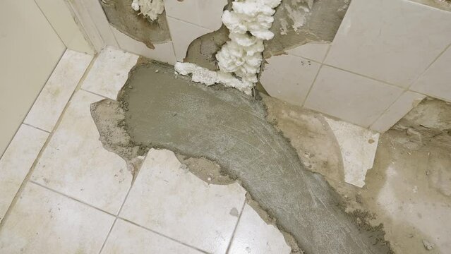 A close up shot of a bathroom floor currently undergoing a full restoration, the drainage pipes have been replaced and wet concrete has been poured to fill the gaps and protect the new pipes