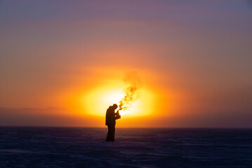 Man on a frozen lake at sunrise. in arctic Canada.