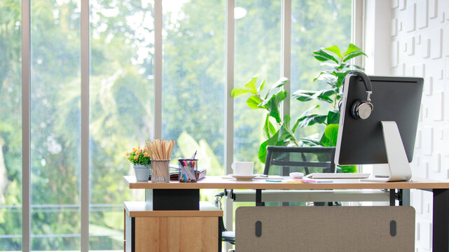 Modern office desk for online work with laptop display, headphone and accessories of note, pen for creative idea recording with coffee cup