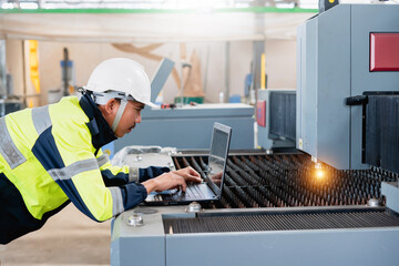 Asian male industrial engineer using laptop He made a gesture while working in a heavy industrial factory.