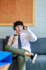 Happy businessman enjoy listening favorite music from wireless earphone with dance acting along song rhythm and drinking cup of coffee for refreshment