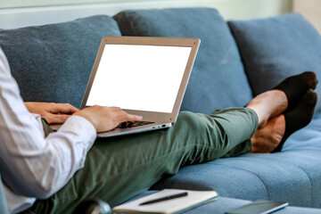 Modern businessman lie down on lobby couch for casual relaxation by stretching legs and working with comfortable laptop for online communication