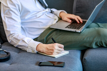 Modern businessmen lie down on lobby couch for casual relaxation by stretching legs and working...