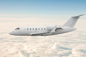 White corporate business jet flies in the air above the clouds