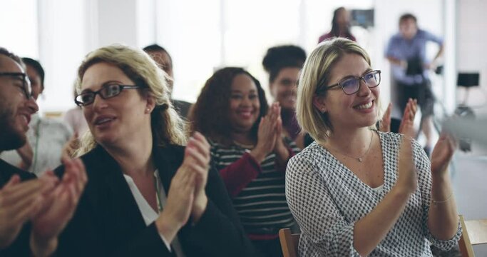 Presentations that inspire passion. Diverse group of business people smiling and clapping with a standing ovation at a conference, applauding during a corporate training seminar meeting