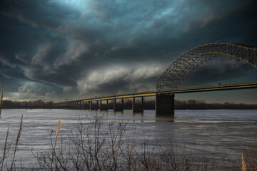 a majestic shot of the Memphis & Arkansas Bridge over the vast flowing waters of the Mississippi...
