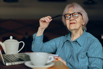 Senior woman working in front of laptop monitor sitting Retired woman chatting unaltered
