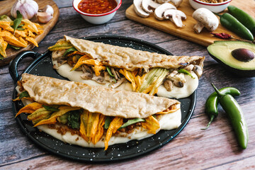 Mexican chicharrón quesadilla with oaxaca cheese and squash blossom, traditional food from the city of Puebla in Mexico
