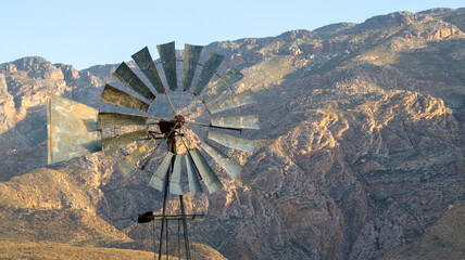 A windmill and a hillside with soft sunlight