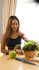 Athletic woman preparing preparing healthy vegan food in the kitchen.