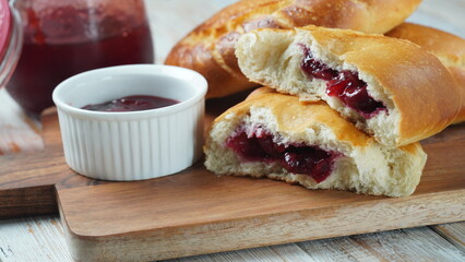 Сherry Pies stuffed with berries cherry, bowl with cherry jam. Homemade sweet pies from yeast dough freshly  baked in oven
