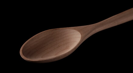 Empty wooden spoon isolated on black background with clipping path