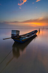 Fototapeta na wymiar Beautiful scenery of a sunrise with a view of a boat