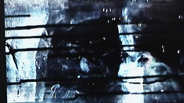 Glitch horror. Dark noise overlay. Video damage. Distressed old film. Blue black white flicker noise on weathered stained texture screen retro effect.