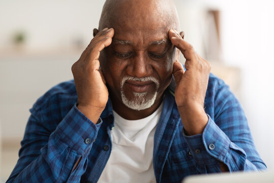 Senior African American Man Suffering From Headache Massaging Temples Indoor